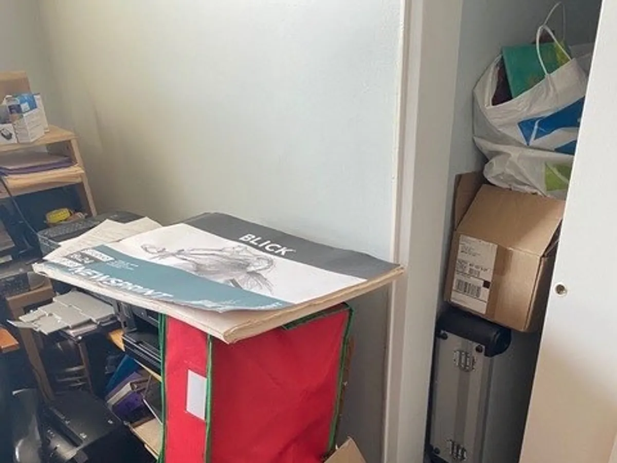 An overfilled closet packed with boxes and bags before organizing