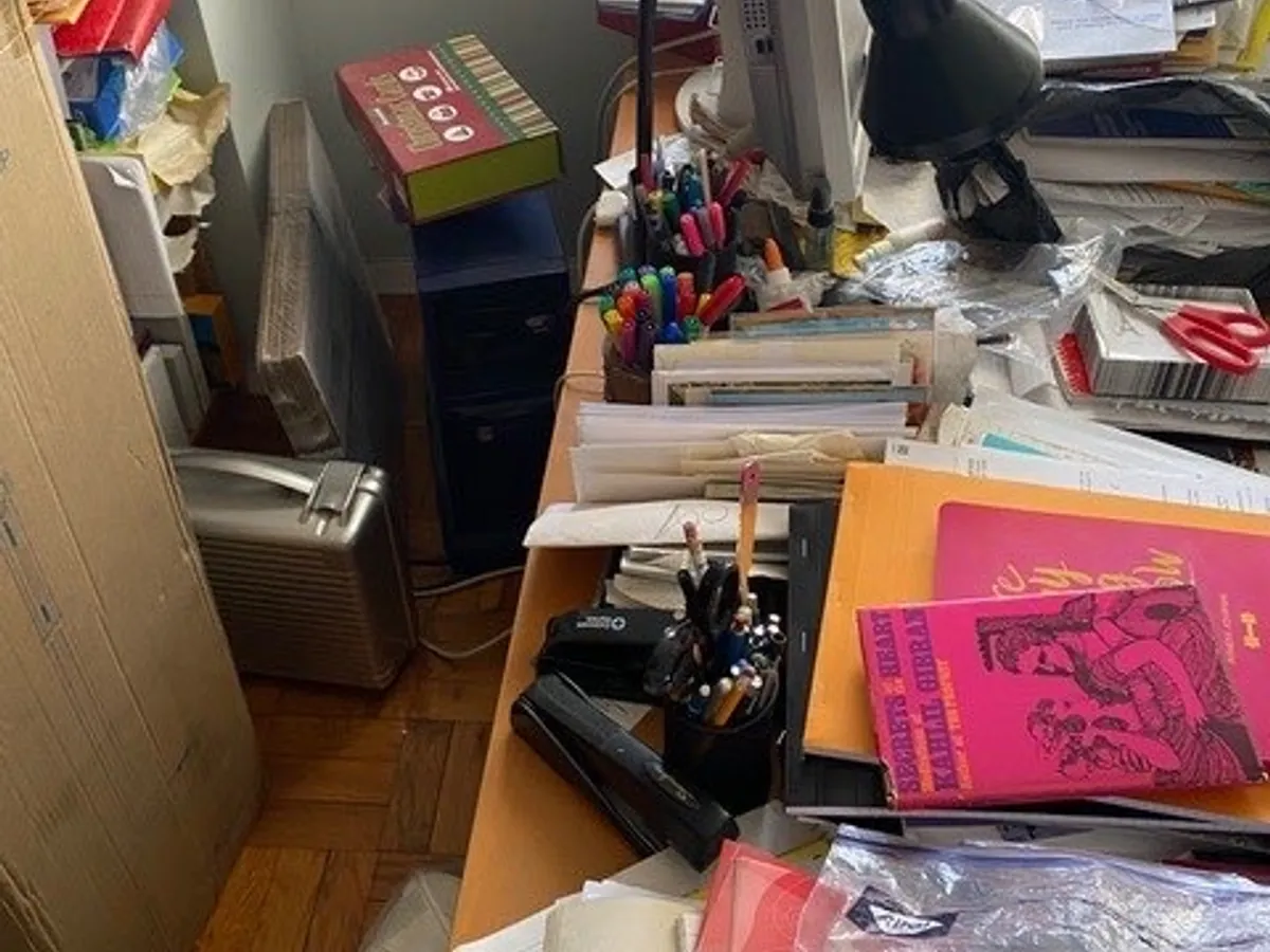 A desk piled with papers before organizing